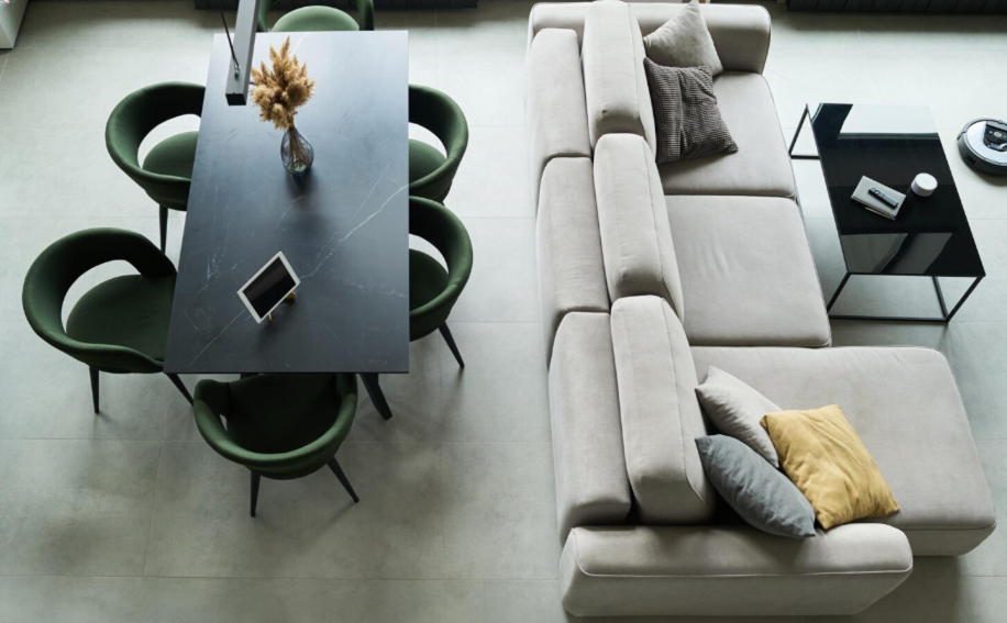 Modern city apartment with a sectional sofa, dining table, green chairs, and space-saving contemporary furniture layout.